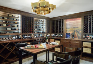 wine room with wood wine racks along the walls and a high tasting table in the center of the room.
