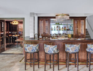 wood bar with custom bar stools and view into the wine room