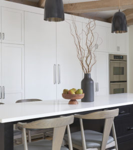 Modern bohemian kitchen island closeup with white storage cabinets in the background